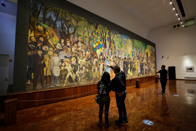 People look on the big painting "Dream of a Sunday Afternoon in Alameda Central Park" in Museum Mural Diego Rivera, famous Mexican painter