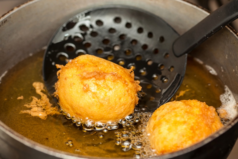 Preparation steps of traditional Colombian dish called stuffed potatoes : Deep frying stuffed pototoes 