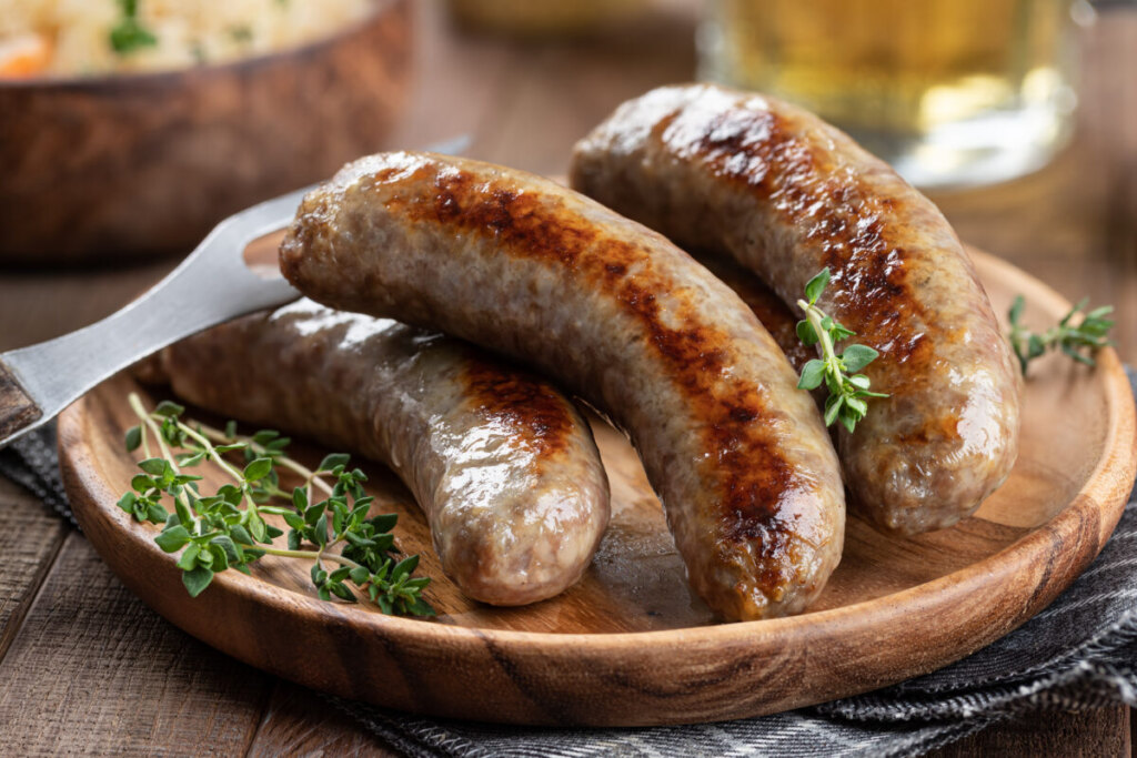 Close-up of a fried bratwurst garnished with thyme