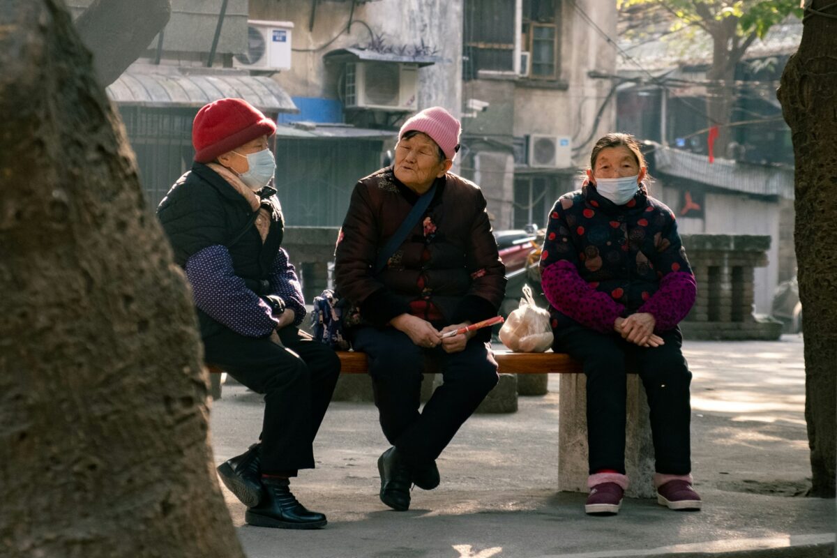 Three elderly Chinese sitting on a bench