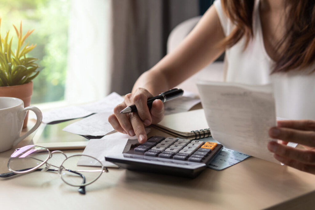 Woman computing tax and expenses with a calculator