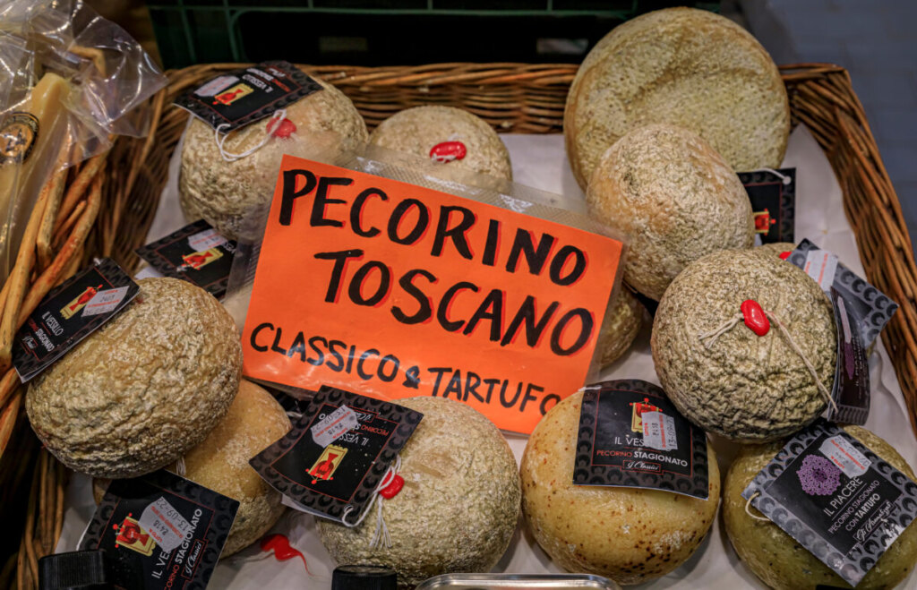 Basket filled with Classic and truffle Tuscan Italian Pecorino cheese for sale on a shop in Florence, Italy