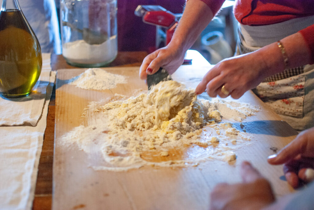 Female hands mixing flour for homemade pasta dough during a cooking class in Italy 