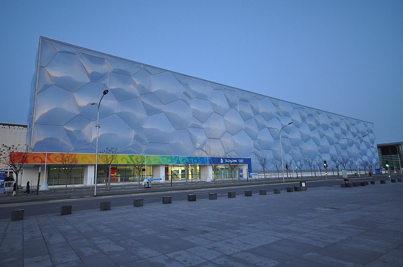 The Beijing National Aquatics Center, also known as the Water Cube, featuring its distinctive bubble-like facade illuminated at night.