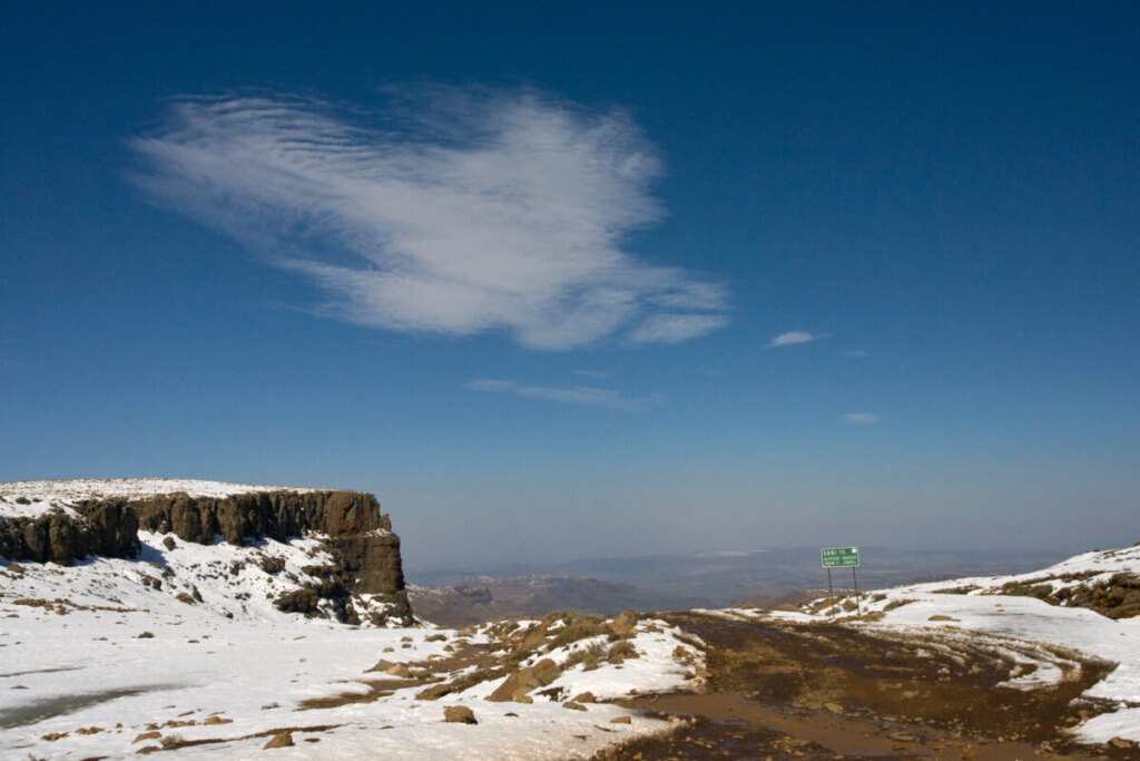 Road surrounded with snow covered mountains and landscape in Sani Pass, Drakensbergen, Lesotho, South Africa