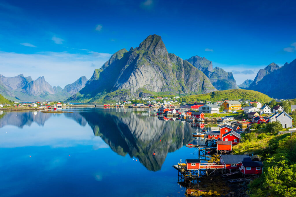 Stunning reflection of Reine village mirrored in the fjord waters of the Lofoten Islands, Norway