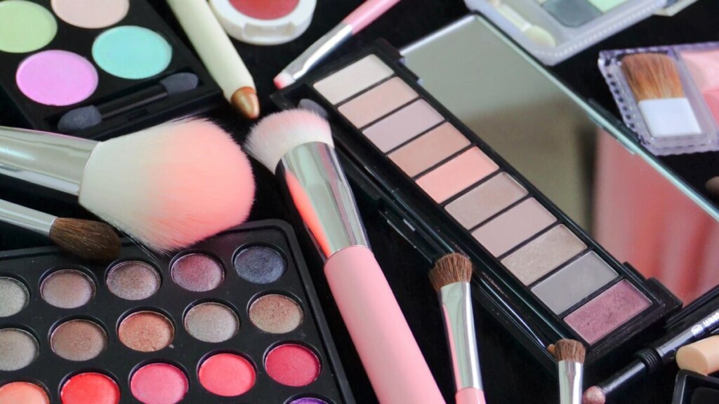 Close-up of different eye shadow palettes and makeup brushes