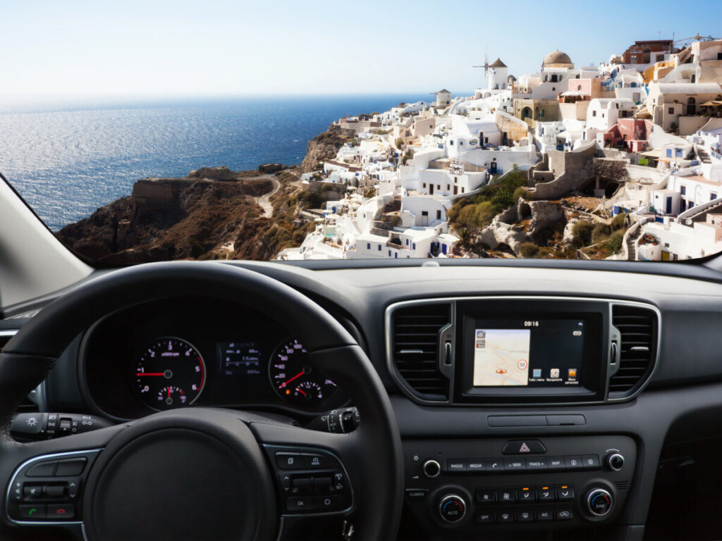 Car dashboard and the view of the Santorini Island from the inside of a car