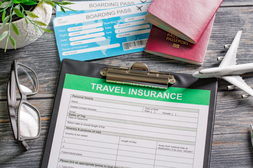 Close-up of travel insurance form, passport, and boarding pass