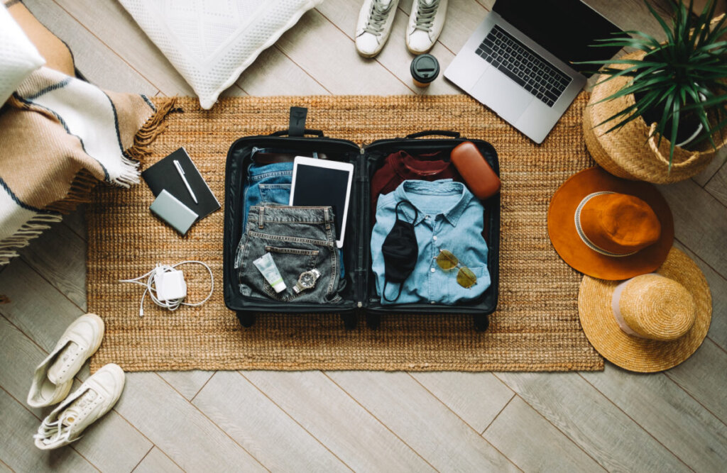 Travel packing a suitcase with clothes and travel essentials